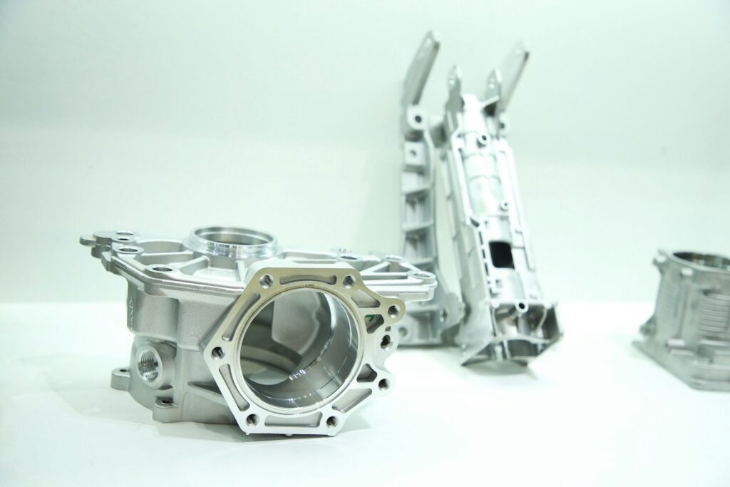 Metal die-cast parts sitting on a table, typical of aluminium components that might be anodised
