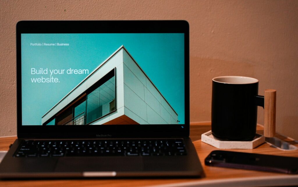 Laptop on a portable table with a mug beside it, ready for website design work